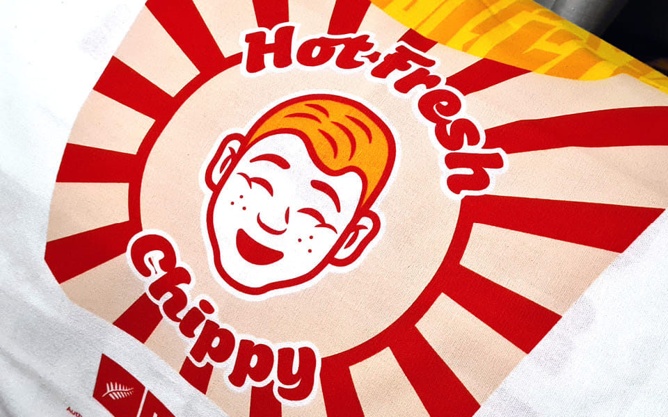 The final design of the Chris Hipkins 'Hot Fresh Chippy' tea towel in a Kiwiana-themed style.