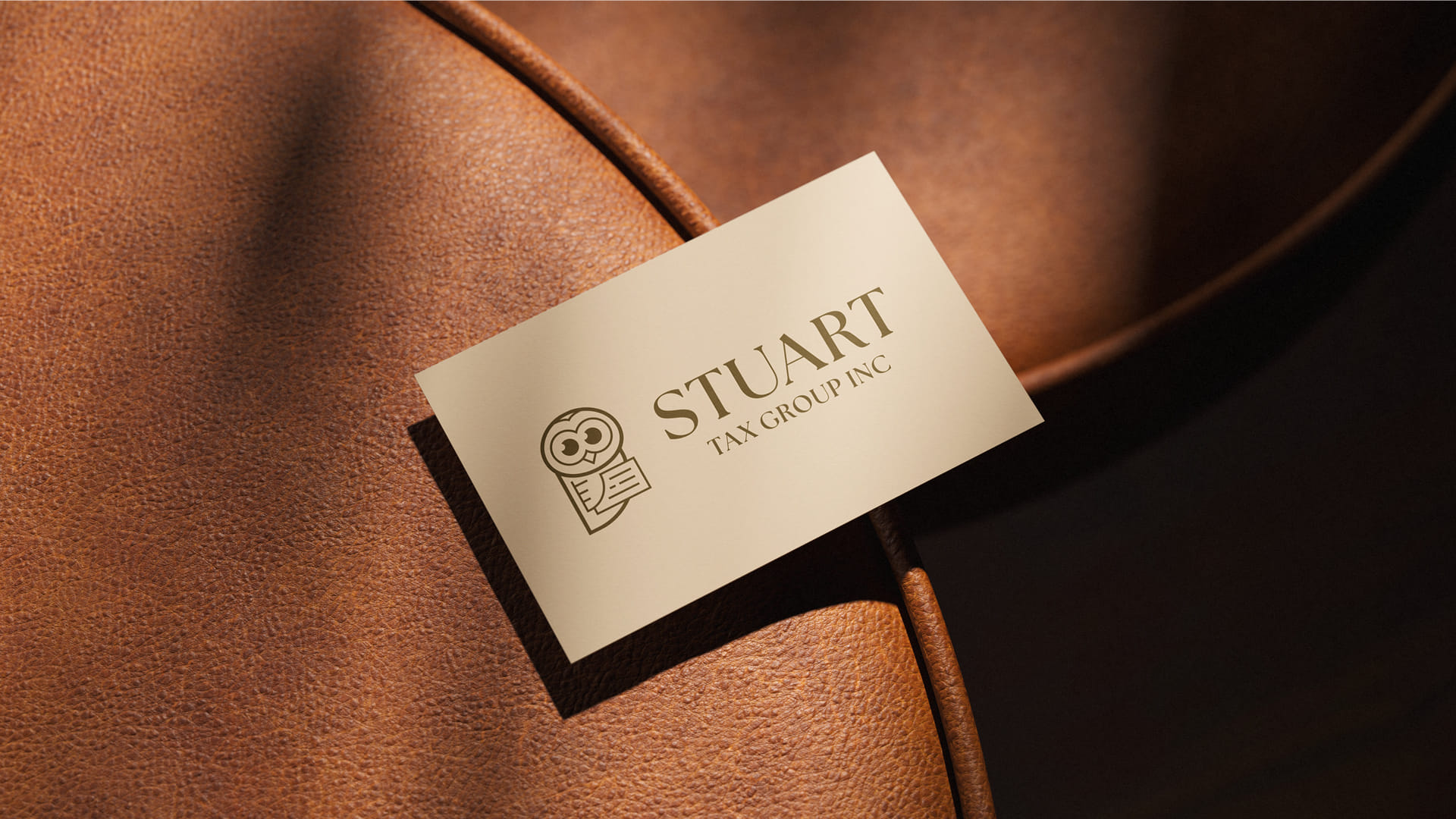 Stuart Tax Group Inc owl logo mockup on a card on a leather chair